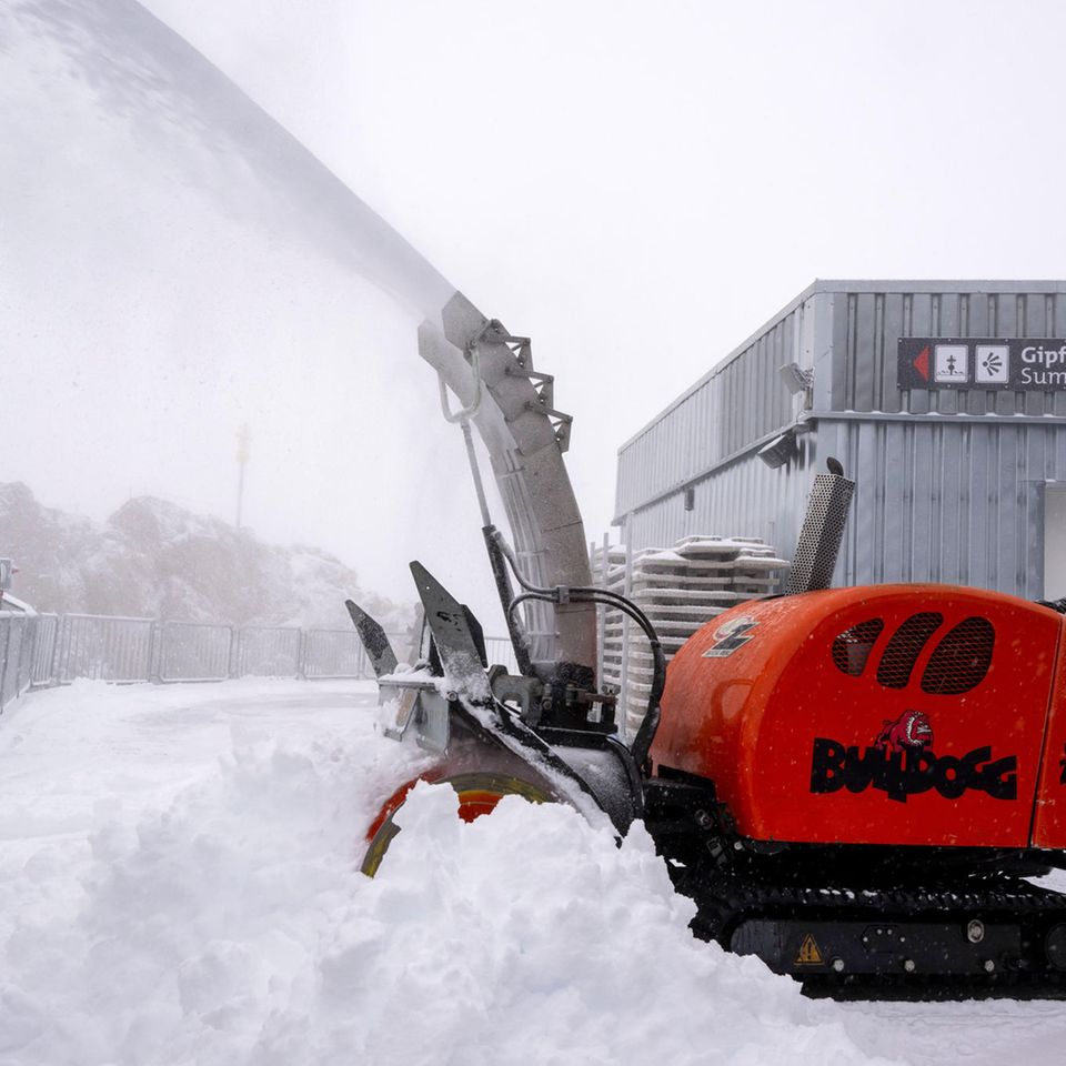 Zugspitze, Deutschland: Dass der Sommer zuende ist, lässt sich auch am ersten Neuschnee ablesen, der das Land erreicht. Auf der Zugspitze liegt der Schnee bereits 15 Zentimeter hoch. Hier räumt eine Frau die Aussichtsplattform