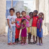 Sieben Kinder unterschiedlichen Alters (Afro-Iraner) stehen nebeneinander.