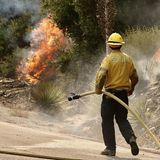 Ein einzelner Feuerwehrmann rückt dem Bridge Fire in Los Angeles County zu Leibe. Hoffentlich weiß er Unterstützung hinter sich