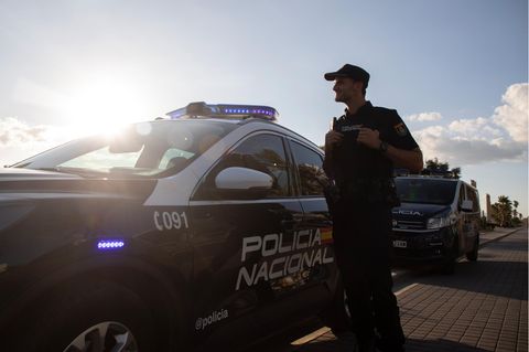 Ein Polizist der Policia Nacional steht auf Mallorca neben seinem Fahrzeug