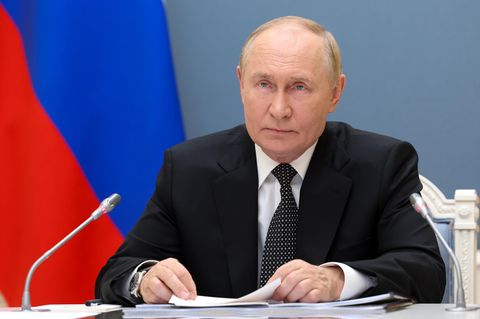 Ukraine-Konflikt: Wladimir Putin sitzt vor einer russischen Flagge