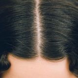 Ausschnitt eines Kopfes mit Mittelscheitel und Wellen von oben