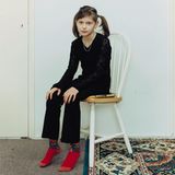 Ein Mädchen mit Zöpfen sitzt auf einem Stuhl