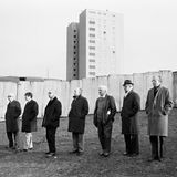 Männer stehen am Rand eines Fußballplatzes