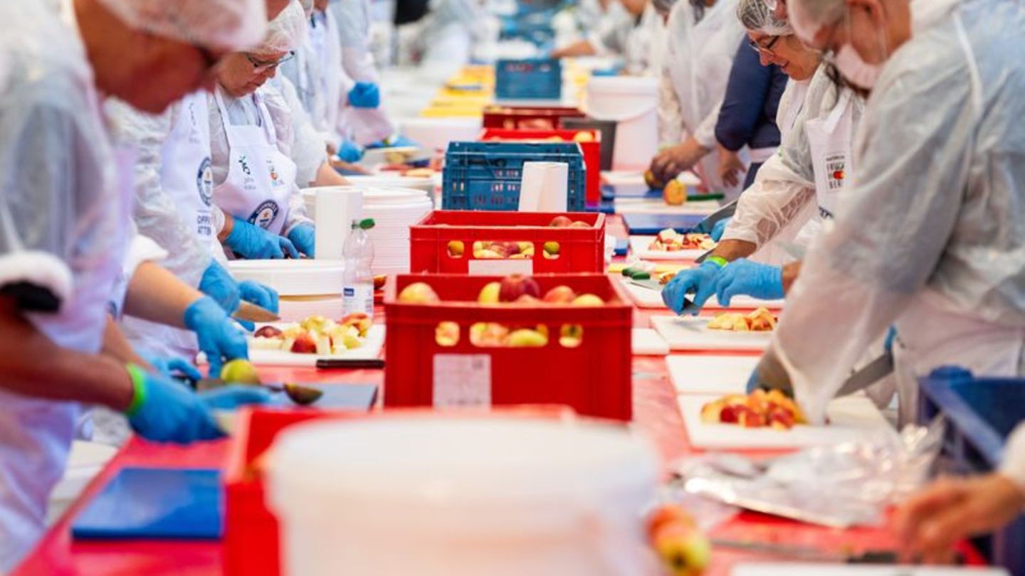 Volle Konzentration: Für den größten Obstsalat der Welt wurden unter anderem Tausende von Äpfeln geschnitten. Foto: Christophe G