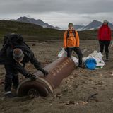 Nachhaltigkeit: Helfer untersuchen eine angespülte russische Abhörboje auf Spitzbergen