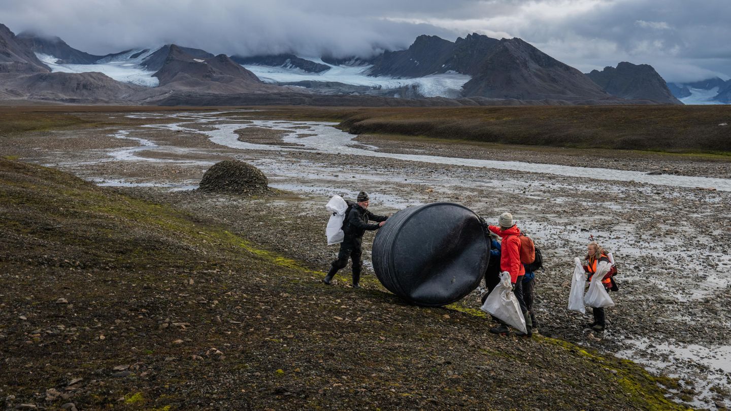 Nachhaltigkeit: Helfer halten auf Spitzbergen eine schwarze Plastik-Tonne fest