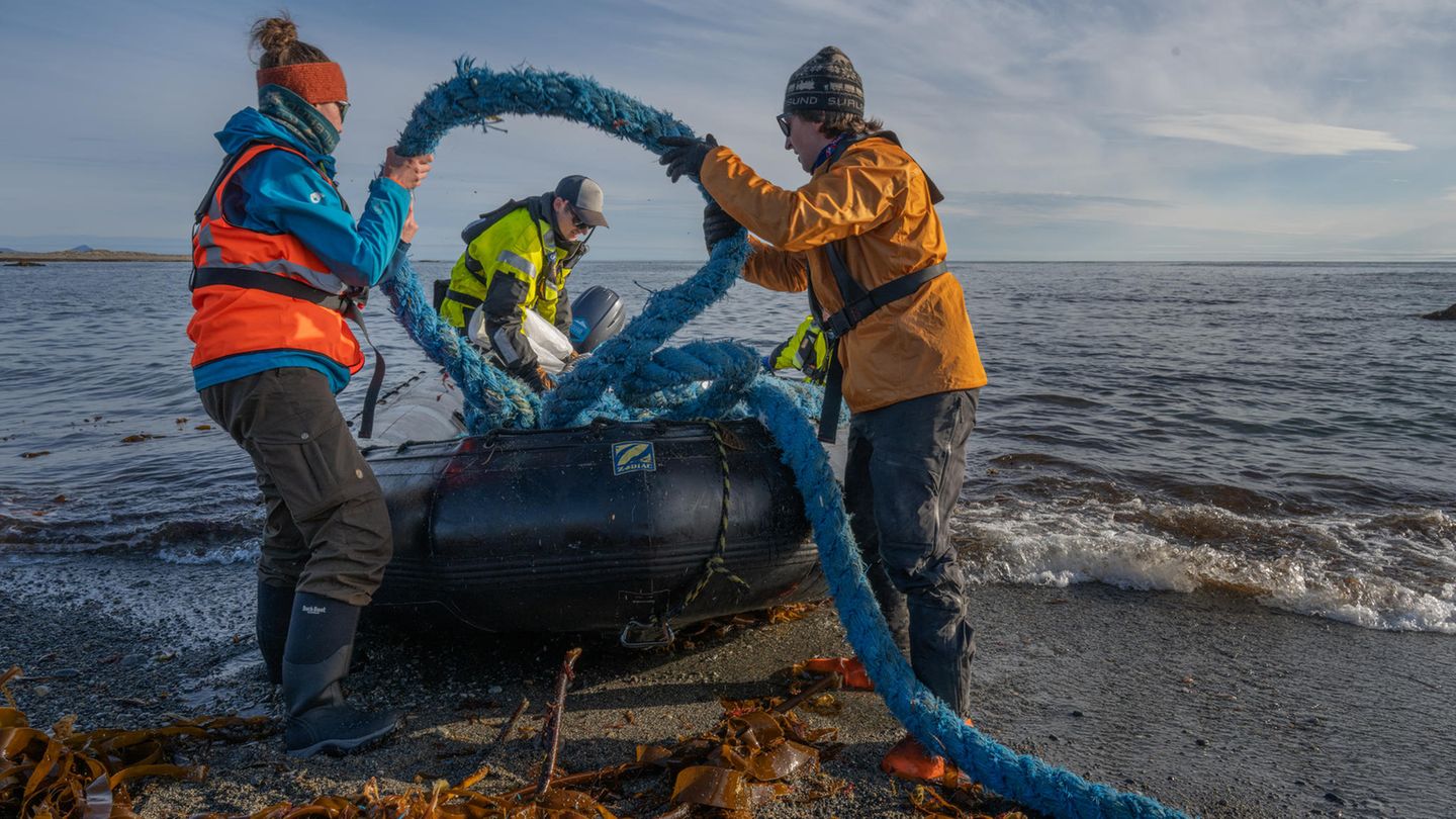 Nachhaltigkeit: Zwei Helfer laden ein angeschwemmtes Schiffstau auf ein Schlauchboot