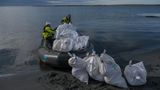 Nachhaltigkeit: Weiße Müllsäcke werden in ein Schlauchboot geladen