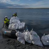 Nachhaltigkeit: Weiße Müllsäcke werden in ein Schlauchboot geladen