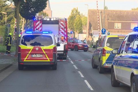 Einsatzkräfte stehen vor einem Bahnübergang in Rees am Niederrhein