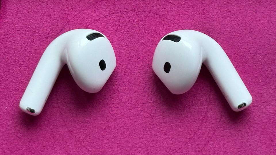 Die Airpods 4 von Apple liegen nebeneinander