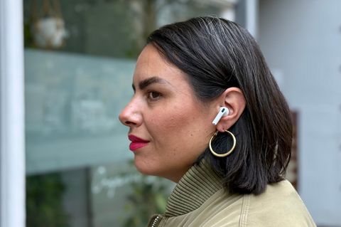 Die Airpods 4 von Apple blockieren für eine junge Frau Straßenlärm