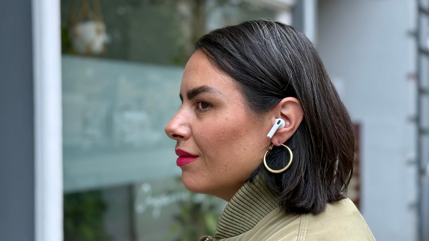 Die Airpods 4 von Apple blockieren für eine junge Frau Straßenlärm