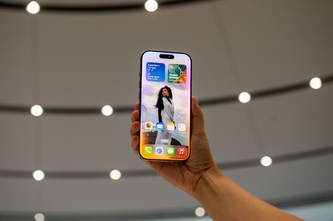 Ein iPhone 16 wird in Cupertino bei der Vorstellung nach oben gehalten. Der Homescreen zeigt iOS 18