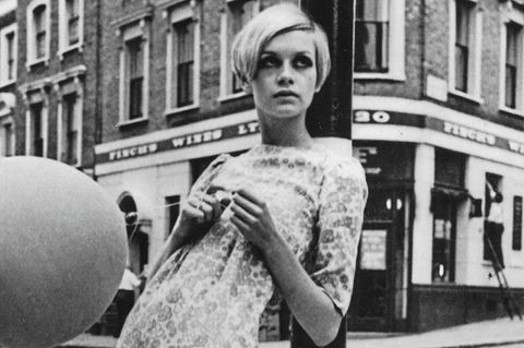 Twiggy in schwarz-weiß, wie sie an einem Laternenpfahl lehnt
