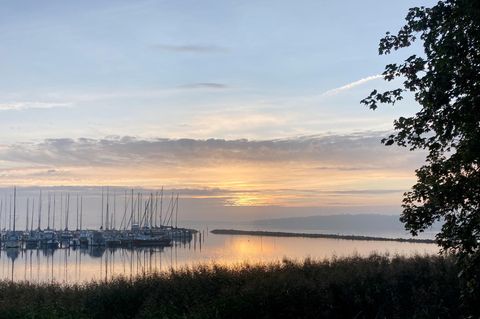 Der Altweibersommer kommt: Die Sonne geht hinter Booten unweit der deutsch-dänischen Grenze in Wassersleben nahe Flensburg auf