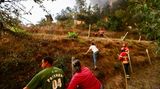 Unterstützt werden sie dabei von Feuerwehrleuten – oft unter widrigen Umständen. Sich an den Hängen Zugang zum Feuer zu verschaffen, ist nicht so leicht