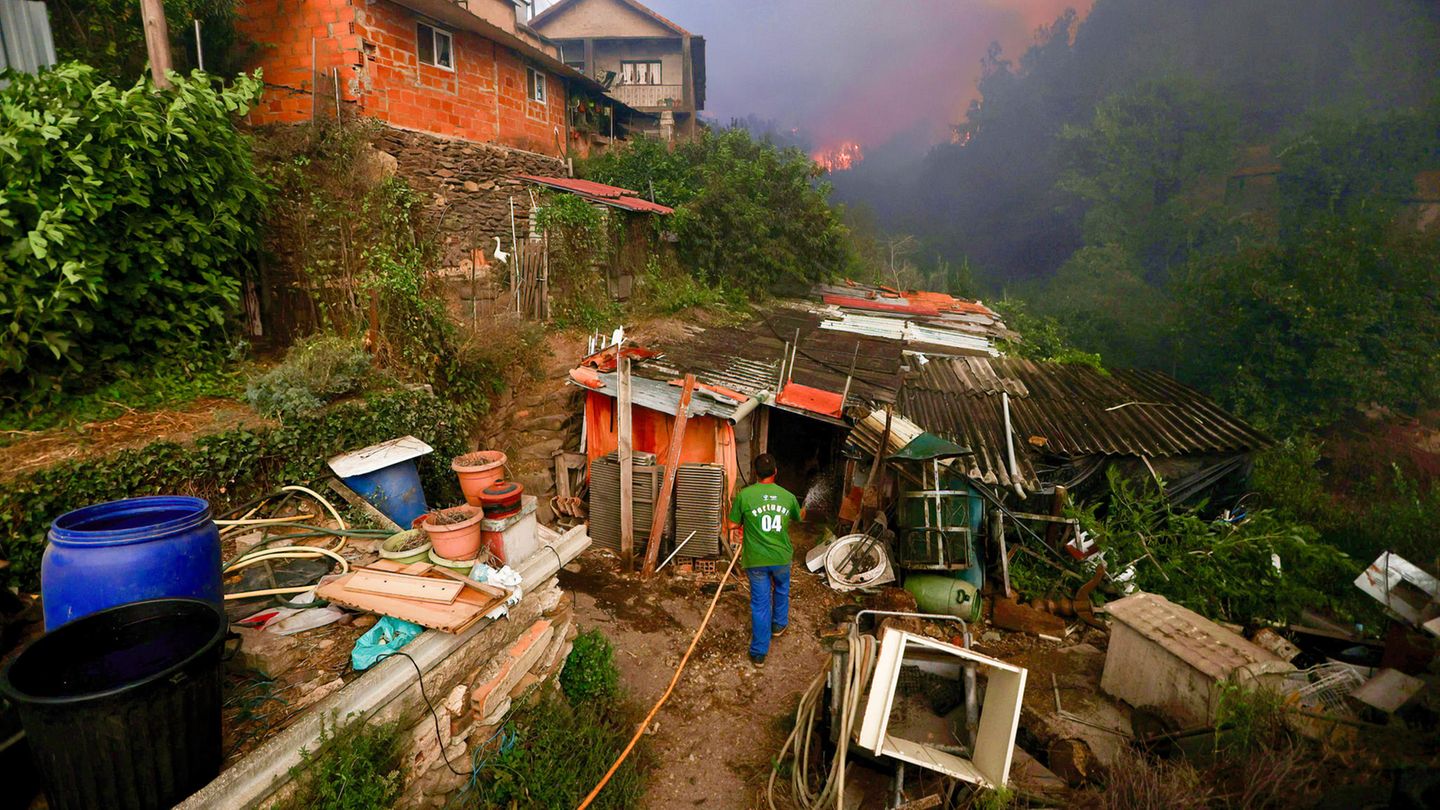 In dem Dorf Busturenga versuchen die Bewohner, ihr Hab und Gut mithilfe von Gartenschläuchen vor den Flammen zu schützen