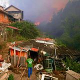 In dem Dorf Busturenga versuchen die Bewohner, ihr Hab und Gut mithilfe von Gartenschläuchen vor den Flammen zu schützen