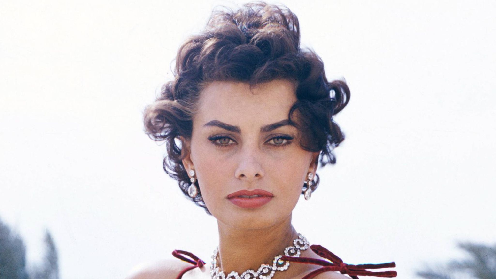 Sophia Loren, 1964 Sophia Loren in rotem Kleid, mit Edelsteinkette, blickt in die Kamera