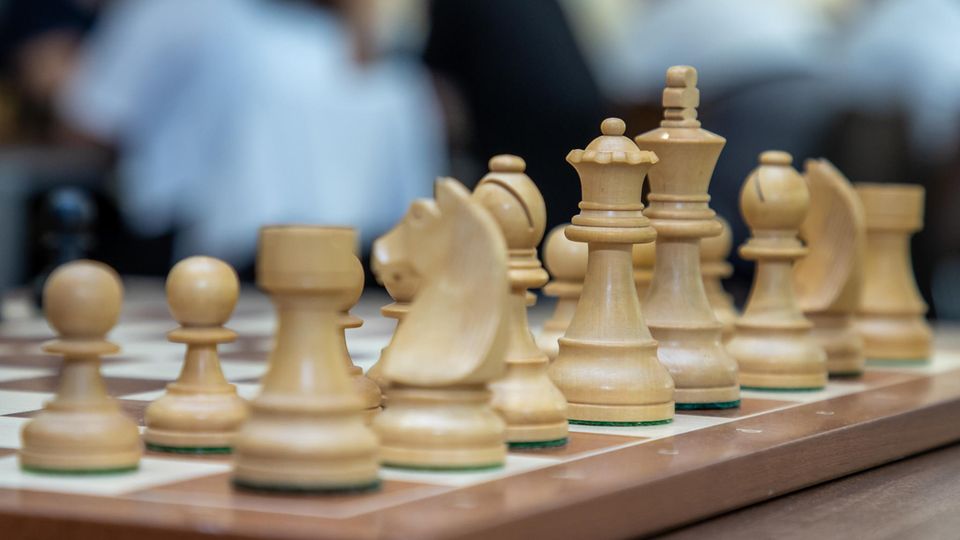 Weiße Figuren stehen auf einem Schach-Brett