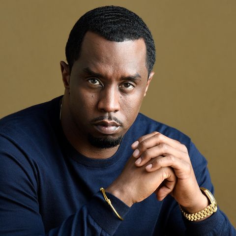 P. Diddy sitzend im blauen Pullover