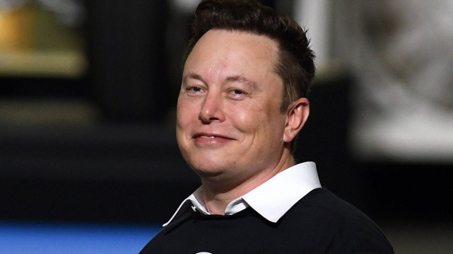 Elon Musk: Der X-Chef grinst vor einem verschwommenen Hintergrund