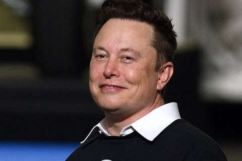 Elon Musk: Der X-Chef grinst vor einem verschwommenen Hintergrund