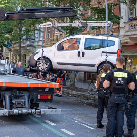 Ein Auto wird aus dem Parkverbot mit einem Kran auf einen Abschleppwagen gehoben – kein Feierabendparken!