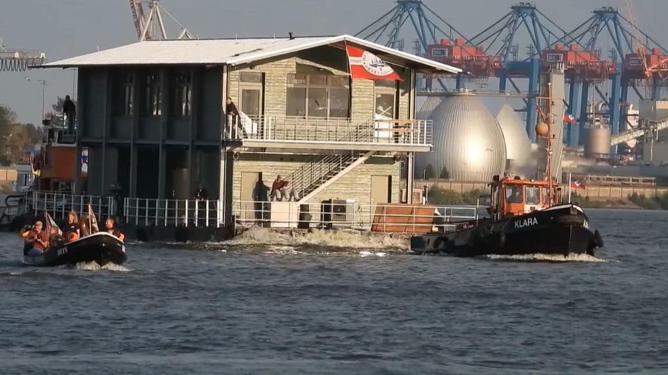 Ein zweistöckiges Haus des Museumshafen Ovelgönne schwimmt durch den Hamburger Hafen.