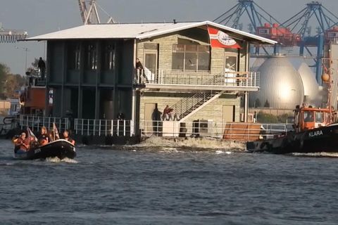 Ein zweistöckiges Haus des Museumshafen Ovelgönne schwimmt durch den Hamburger Hafen.