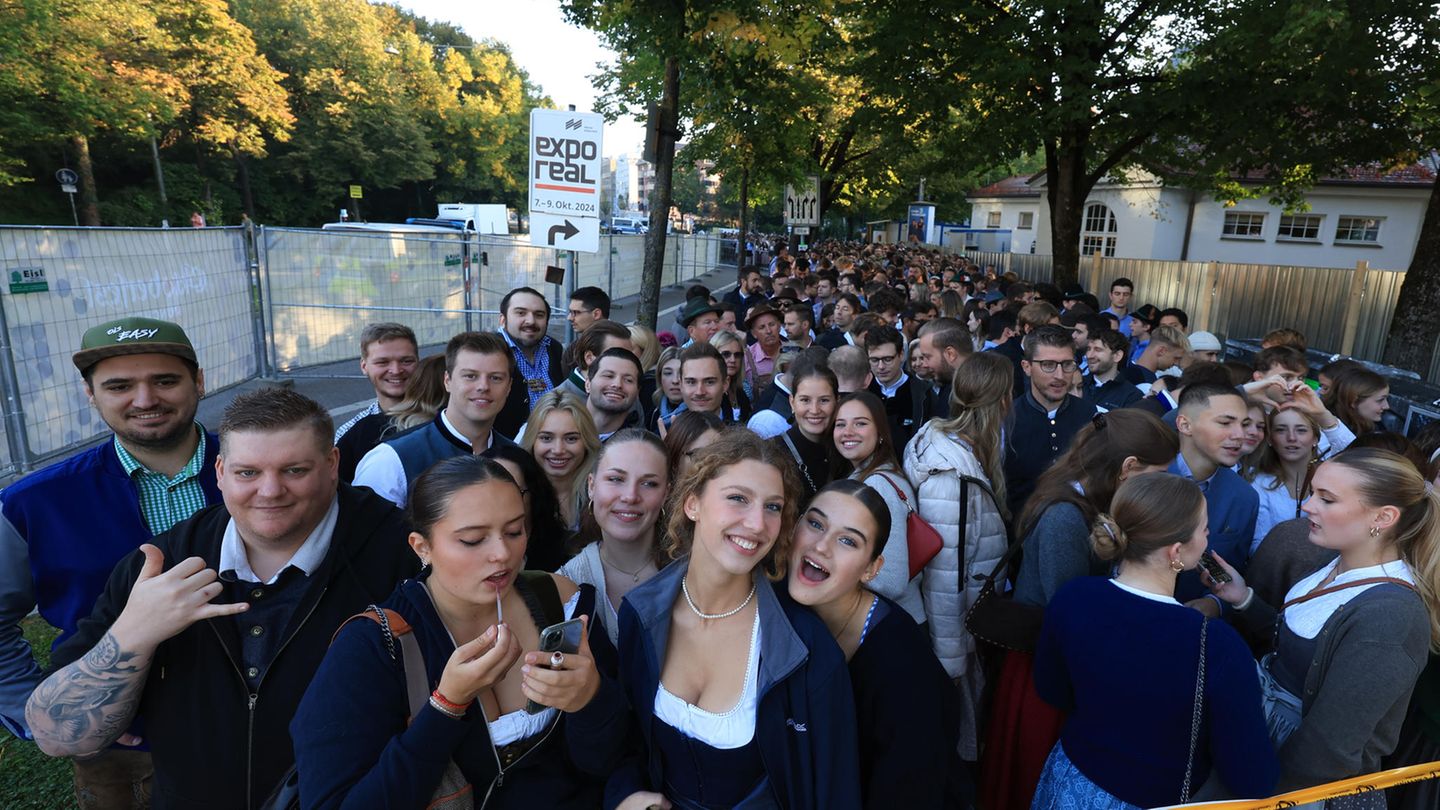 Junge Leute in Trachtenkleidung warten auf den Einlass zum Oktoberfest Junge Leute in Trachtenkleidung warten auf den Einlass zum Oktoberfest