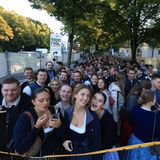 Junge Leute in Trachtenkleidung warten auf den Einlass zum Oktoberfest