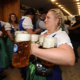 Serviererin trägt sieben oder acht Krüge Bier auf einmal