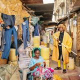 Cosplayer Denis posiert mit seiner Mutter in seinem Cosplay Outfit in ihrer Lehmhütte zwischen Wäscheleinen