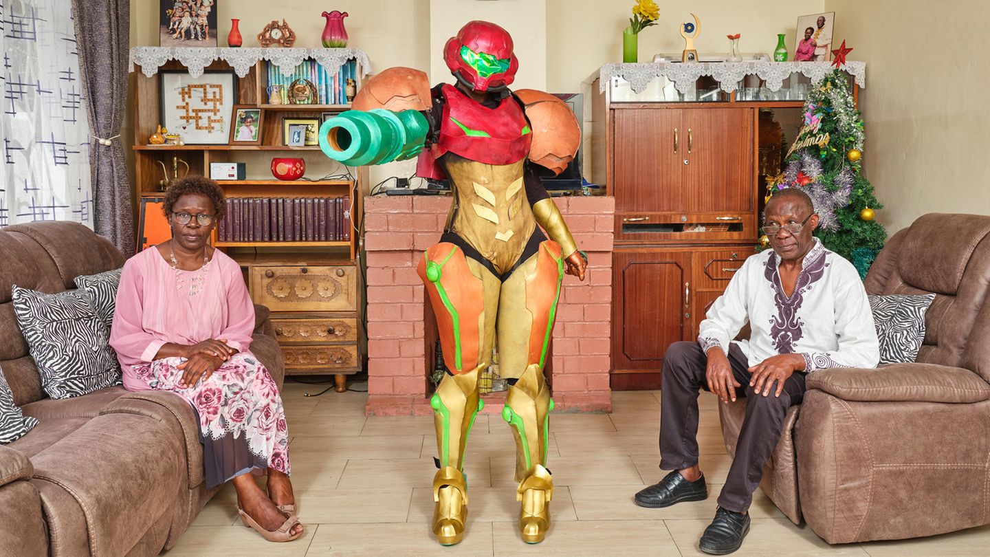 Cosplayerin Jess posiert als Videospielfigur mit ihren Eltern in deren Wohnzimmer