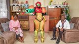 Cosplayerin Jess posiert als Videospielfigur mit ihren Eltern in deren Wohnzimmer