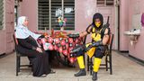 Cosplayer Asgar posiert als "Scorpion" aus dem Videospiel "Mortal Kombat" mit seiner Mutter in deren Küche