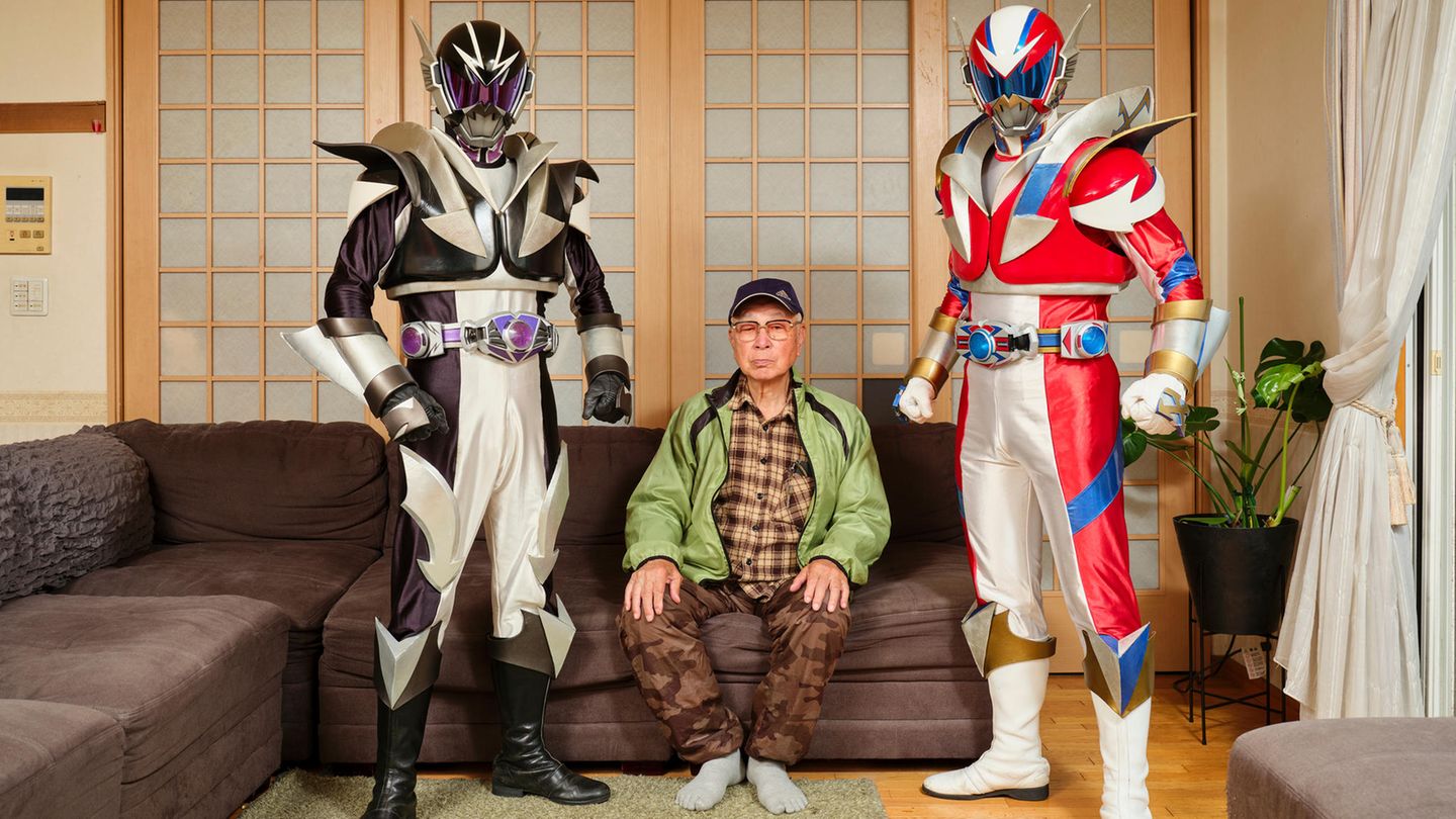 Cosplayer Ren und sein Vater Atsushi posieren gemeinsam mit dem Großvater in Superhelden Kostümen