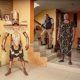 Cosplayer Nicky posiert als "God of Iron" mit seinem Onkel und seiner Tante im Wohnzimmer