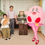 Cosplayer Dokutokunaugoki posiert mit ihren Eltern und dem Familienhund als Videospielcharakter "Kirby"
