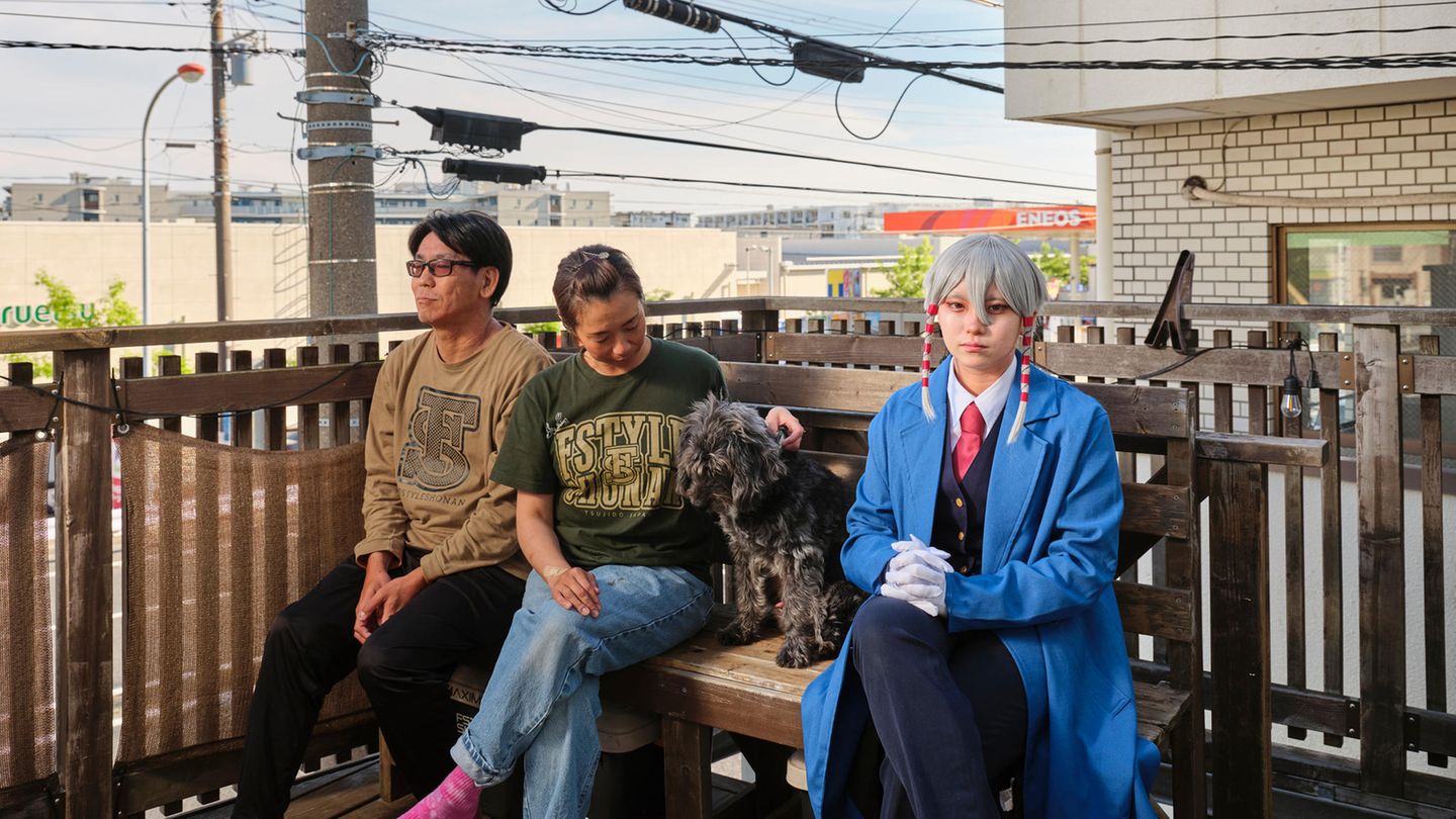 Cosplayerin Utsuro posiert mit ihren Eltern und deren Hund in ihrem Kostüm