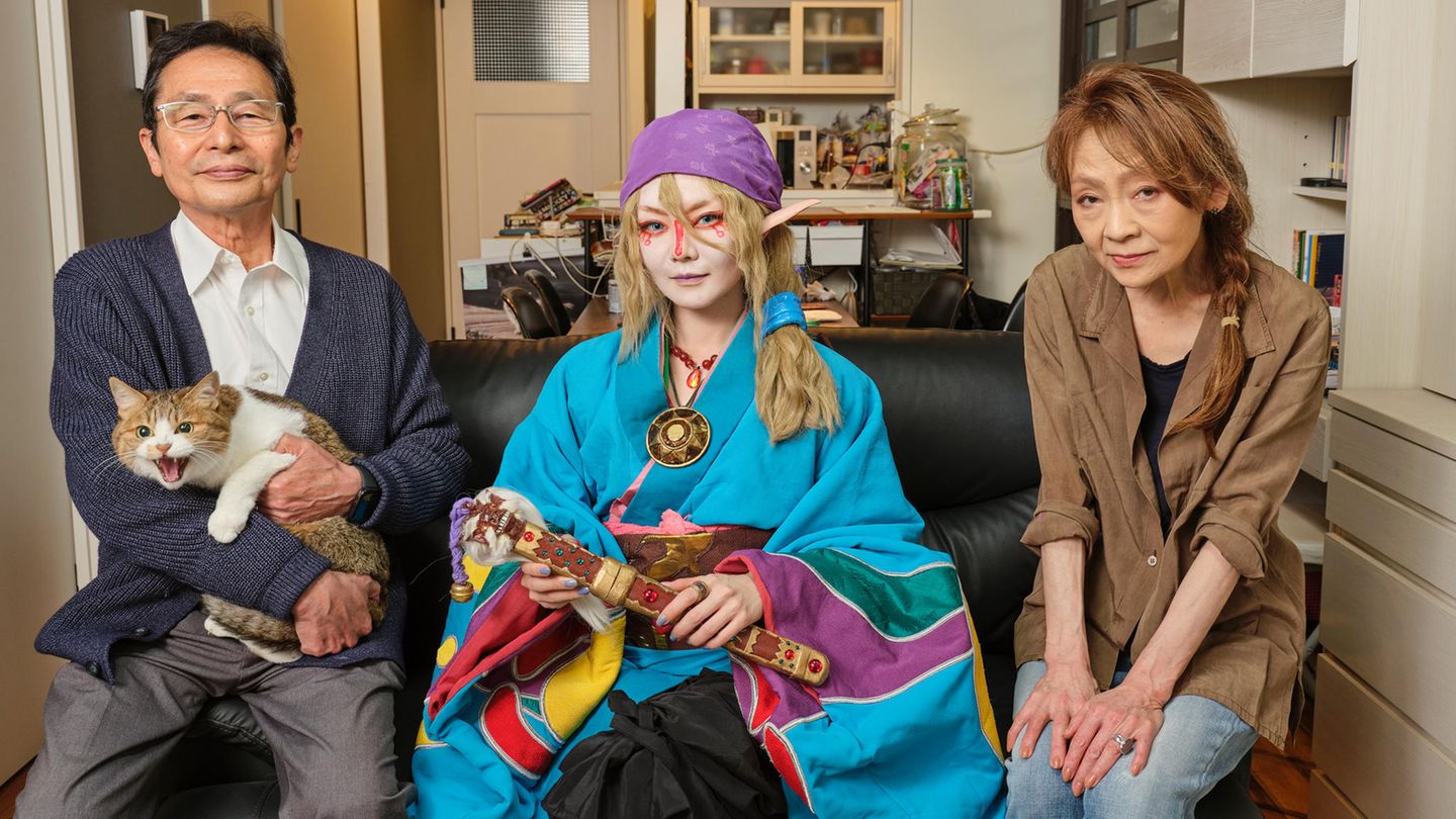 Cosplayerin Mahio, 40, posiert mit ihren Eltern und ihrer Katze auf dem Sofa ihres Hauses in Tokio Cosplayerin Mahio, 40, posiert mit ihren Eltern und ihrer Katze auf dem Sofa ihres Hauses in Tokio