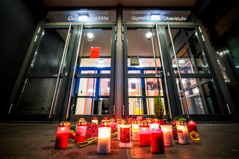 Vor der Gesamtschule Duisburg-Mitte stehen Kerzen und liegen Blumen