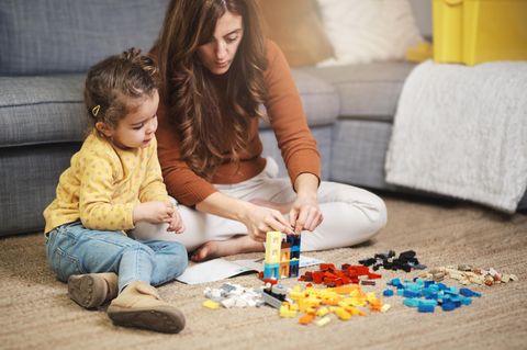 Mutter und Tochter spielen mit einem Lego-Set.