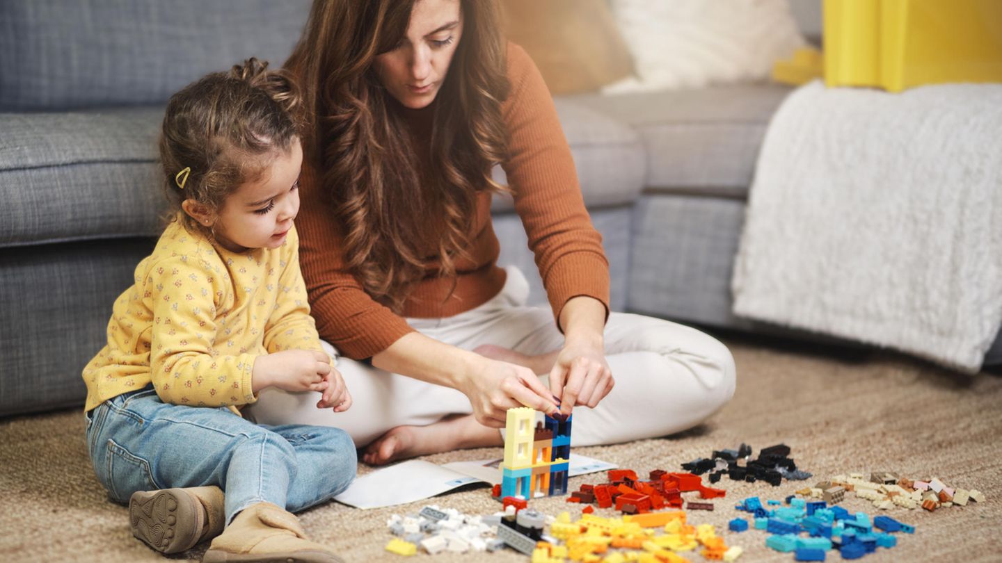 Mutter und Tochter spielen mit einem Lego-Set.