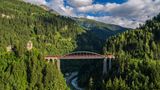 OEBB-Zug fährt über eine Brücke in Tirol