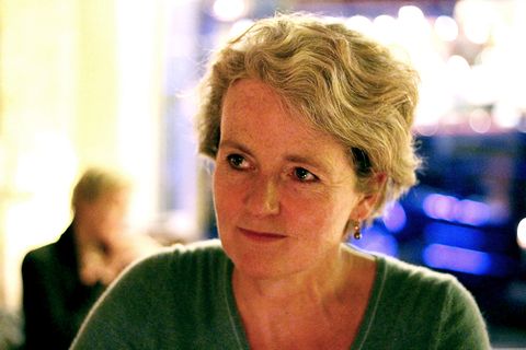 Porträt einer mittelalten Frau mit kurzen Haaren im dämmrigen Licht einer Abendveranstaltung.