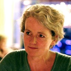 Porträt einer mittelalten Frau mit kurzen Haaren im dämmrigen Licht einer Abendveranstaltung.
